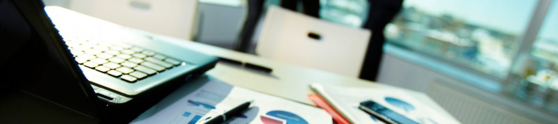 Documents at workplace Image of business documents on workplace with three partners interacting on background
